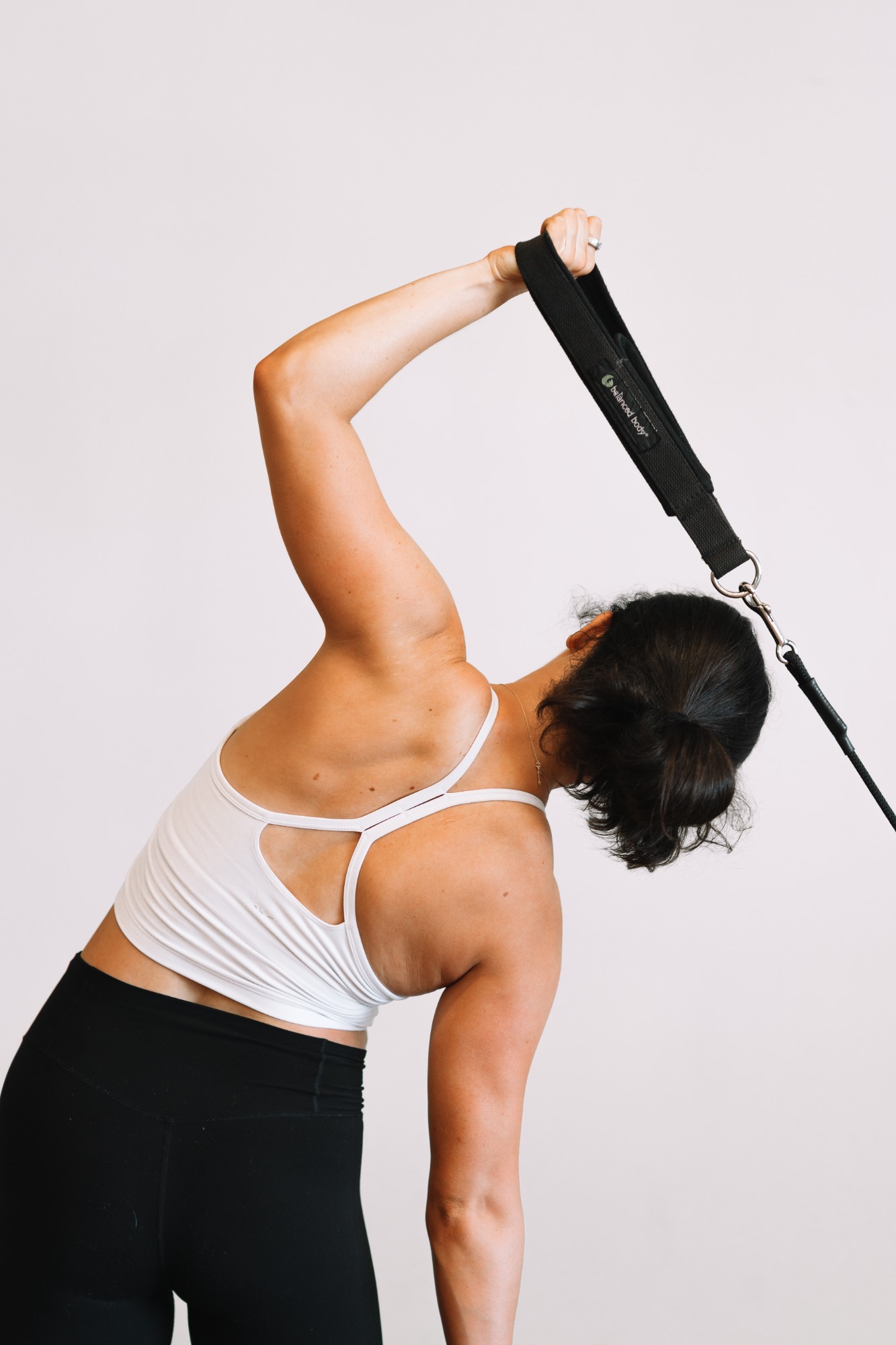Brett side-bending with a Pilates strap held overhead